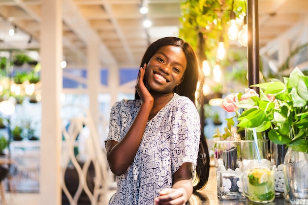 Portrait of young african woman standing in cafe