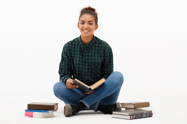 Portrait of young african woman with books on white.