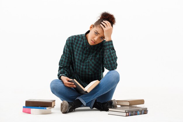 Portrait of young african woman with books on white.