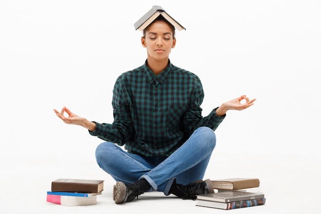 Portrait of young african woman with books on white.