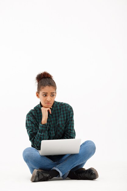 Portrait of young african woman with laptop on white