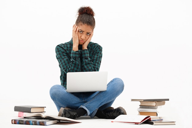 Free photo portrait of young african woman with laptop on white