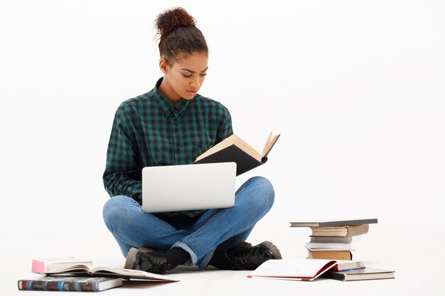 Portrait of young african woman with laptop on white