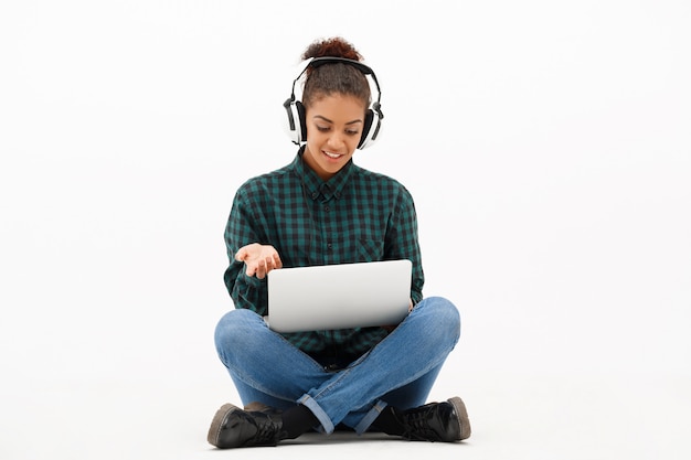 Portrait of young african woman with laptop on white