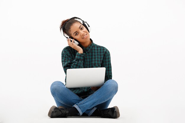 Portrait of young african woman with laptop on white