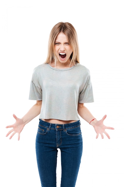 Portrait of a young angry woman standing and screaming