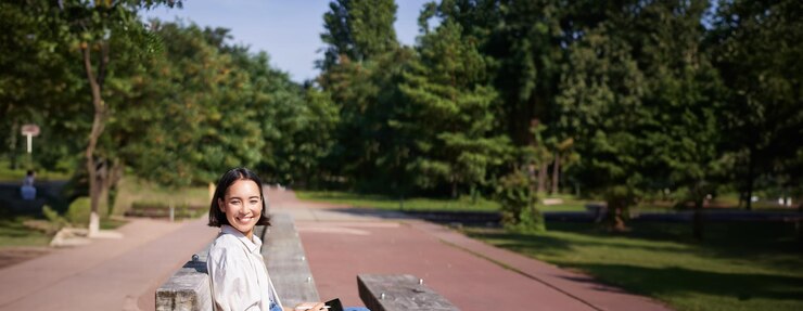 무료 Photo 젊은 예술가 아시아 소녀의 초상화 디지털 태블릿에서 그래픽 펜으로 야외에 앉아