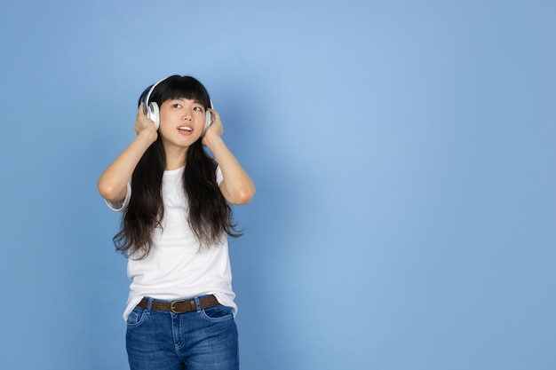 Portrait of young asian woman isolated on blue