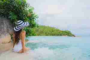 Free photo portrait young asian woman relax smile happy around outdoor swimming pool in hotel resort with sea ocean view