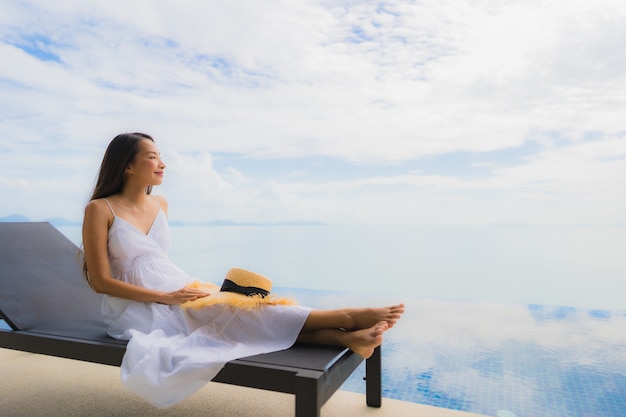 Portrait young asian woman relax smile happy around swimming pool in hotel and resort