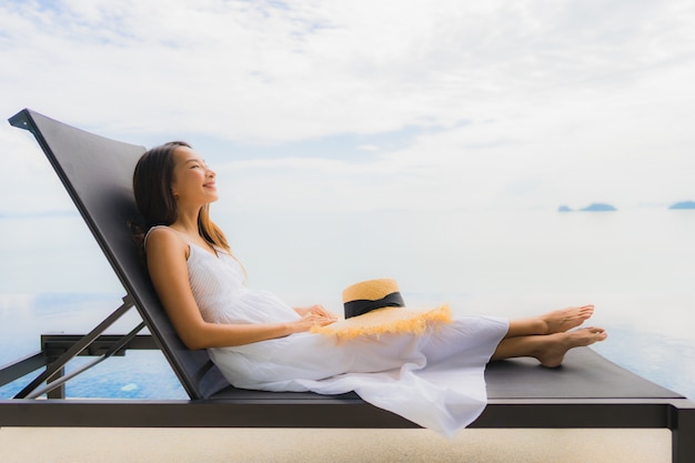 Portrait young asian woman relax smile happy around swimming pool in hotel and resort