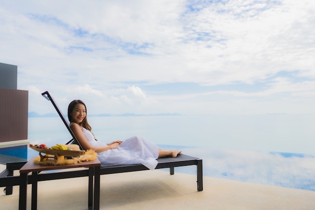 Free photo portrait young asian woman relax smile happy around swimming pool in hotel and resort