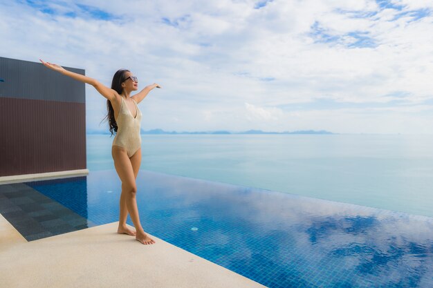 세로 젊은 아시아 여자는 호텔과 리조트 수영장 주위에 미소 행복 휴식