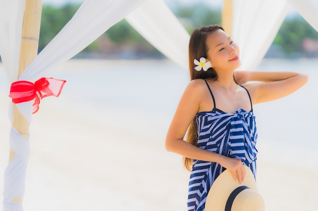 休日の休暇のためのココヤシの木とビーチ海海の周り幸せな肖像画若いアジア女性笑顔