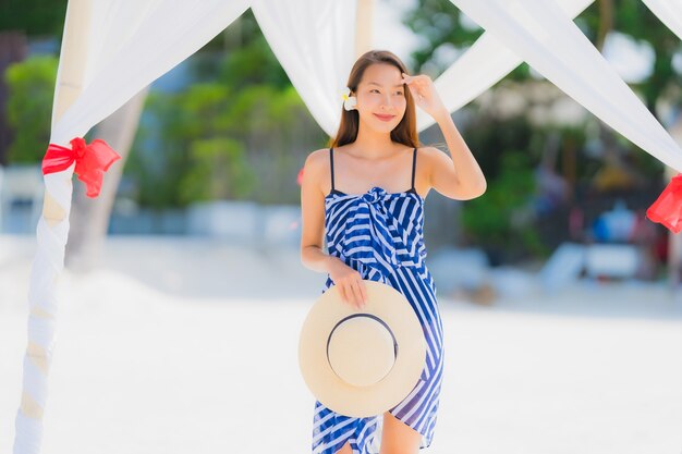 休日の休暇のためのココヤシの木とビーチ海海の周り幸せな肖像画若いアジア女性笑顔