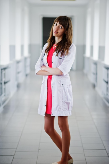 Portrait of a young attractive doctor in white coat with stethoscope posing in the hospital