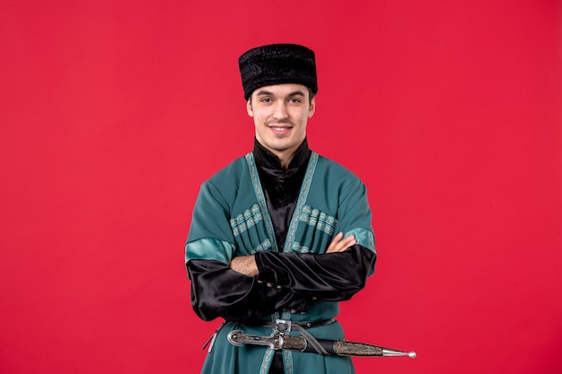 Portrait of young azeri man in traditional costume on red