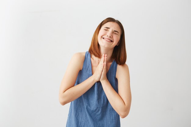 Portrait of young beautiful brunette girl praying .