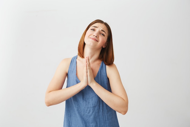 Portrait of young beautiful brunette girl praying .