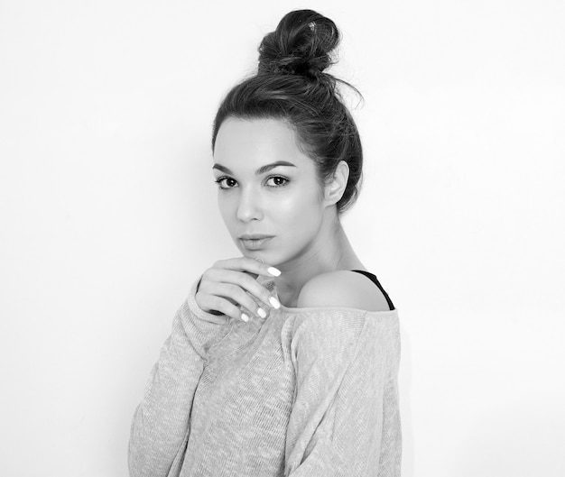 Portrait of young beautiful brunette woman girl model with nude makeup in summer clothes posing near wall. 