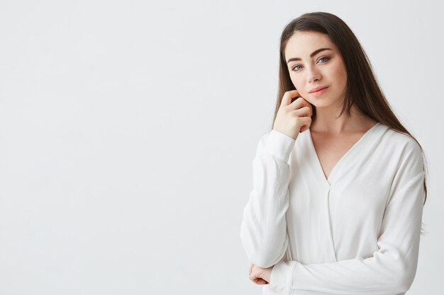 Portrait of young beautiful business lady smiling touching face .