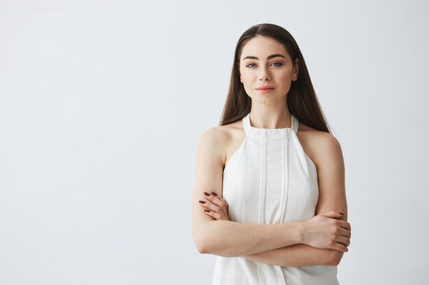 Portrait of young beautiful businesswoman with crossed arms .