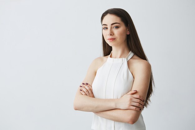 Portrait of young beautiful businesswoman with crossed arms .