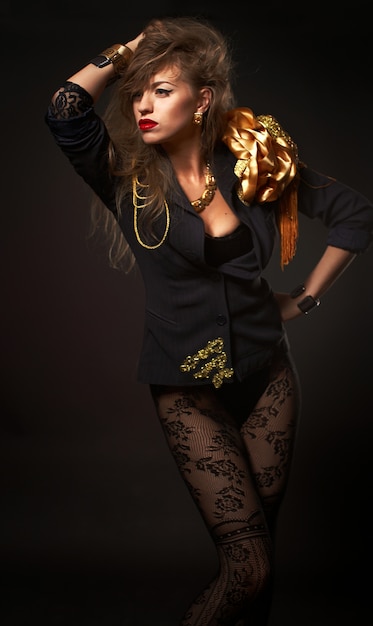 Portrait of young beautiful caucasian blonde woman in fashion gold body