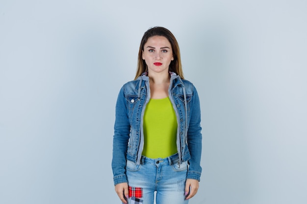 Portrait of young beautiful female looking in denim outfit and looking gloomy front view