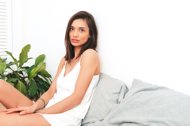 Portrait of young beautiful female in white pajamas