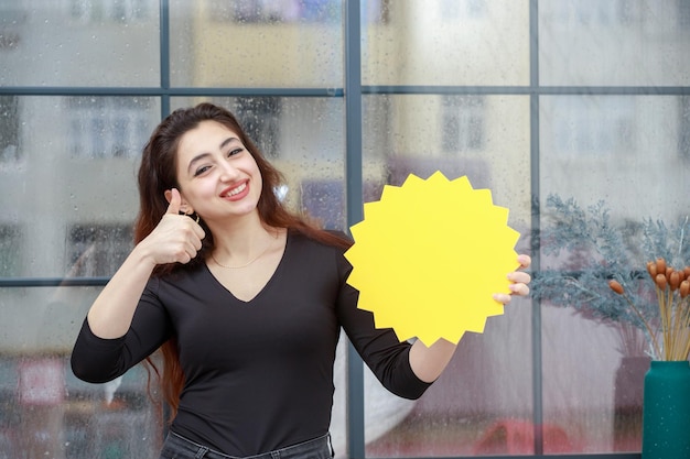 Portrait of young beautiful girl holding idea bubble and gesture thumb up while smiling high quality photo