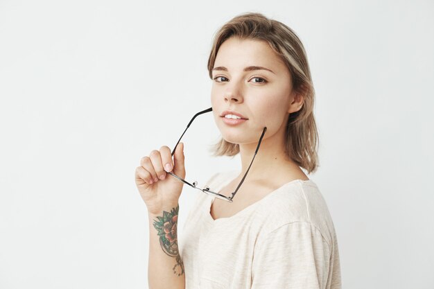 Portrait of young beautiful girl smiling holding glasses .