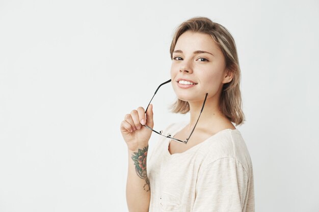 Portrait of young beautiful girl smiling holding glasses .