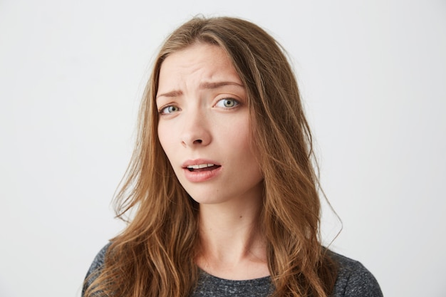 Portrait of young beautiful girl suspiciously with opened mouth .