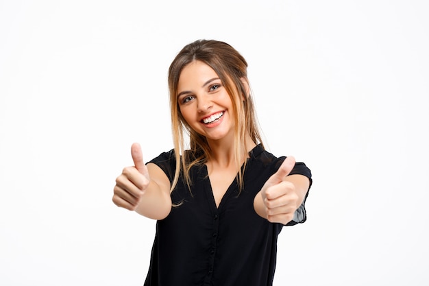 Portrait of young beautiful girl over white background. Thumbs up