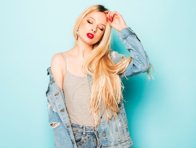 Portrait of young beautiful hipster bad girl in trendy jeans  clothes and earring in her nose.  Positive model having fun