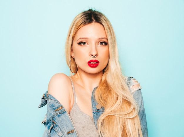 Portrait of young beautiful hipster bad girl in trendy jeans  clothes and earring in her nose.  Positive model having fun