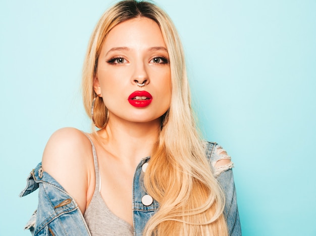 Portrait of young beautiful hipster bad girl in trendy jeans  clothes and earring in her nose.  Positive model having fun