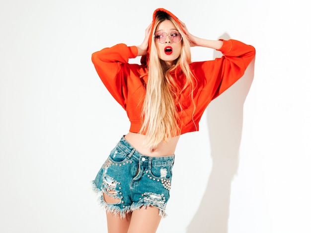 portrait of young beautiful hipster bad girl in trendy red  hoodie and earring in her nose.  positive model having fun.isolated on white