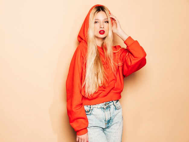 Portrait of young beautiful hipster bad girl in trendy red  hoodie and earring in her nose.  Positive model