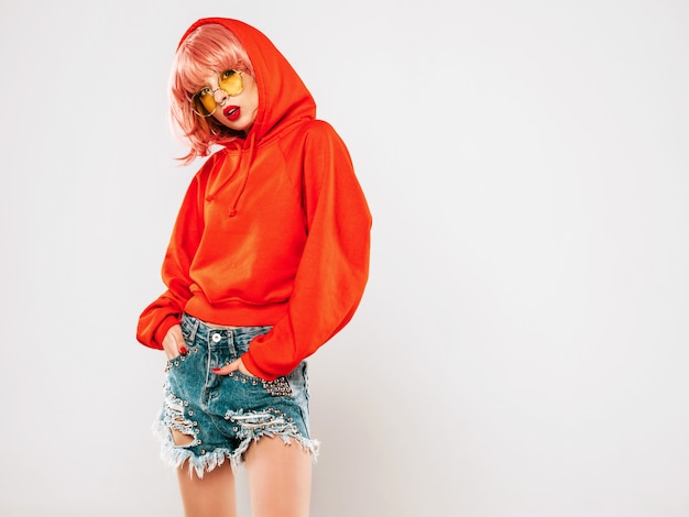 Portrait of young beautiful hipster bad girl in trendy red summer hoodie and earring in her nose. summer Positive model in wig