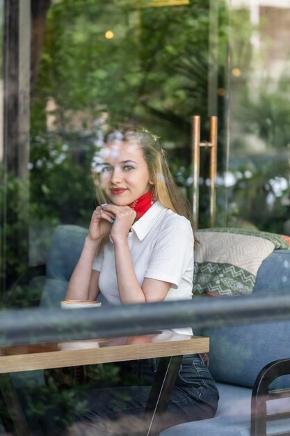 Portrait of young beautiful lady sitting at the restaurant and looking at the camera