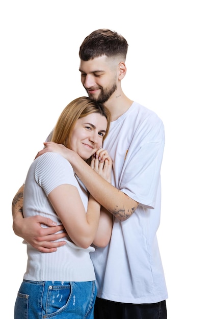 Portrait of young beautiful loving couple hugging posing isolated over white studio background