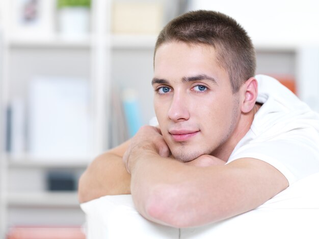 Portrait of young beautiful man lying on the sofa