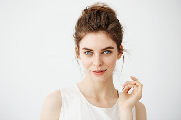 Portrait of young beautiful playful woman with bun posing.