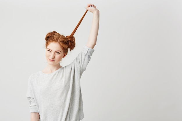 Портрет молодой красивой рыжеволосой девушки развязать плюшку трогательные волосы.