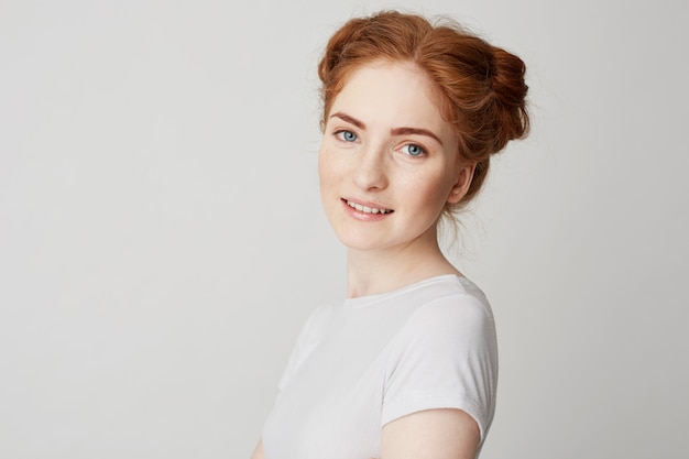 Portrait of young beautiful redhead girl with freckles smiling .