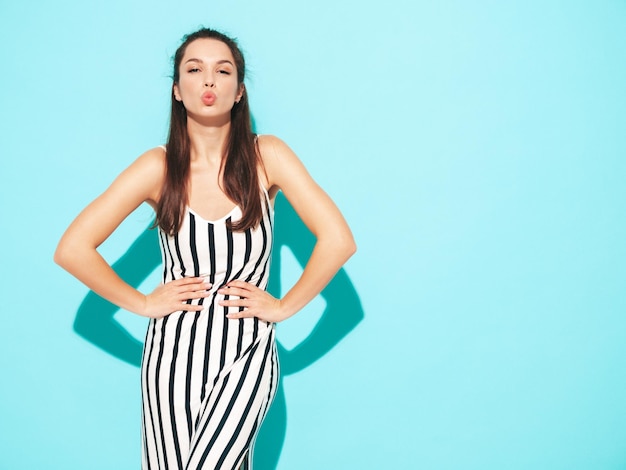 Free photo portrait of young beautiful smiling female in trendy summer clothes sexy carefree woman posing in studio positive brunette model having fun and going crazy cheerful and happy