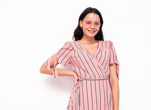 Portrait of young beautiful smiling female in trendy summer pink dress Sexy carefree woman posing isolated on white in studio Positive model having fun indoors Cheerful and happy