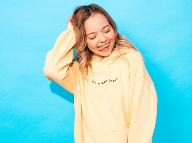 Portrait of young beautiful smiling girl in trendy summer hipster yellow hoodie